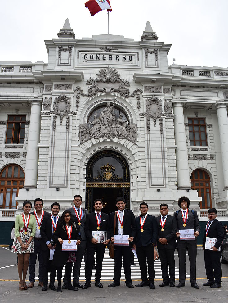 Parlamentarios jóvenes en las afueras del Congreso muestran sus certificados de participación.